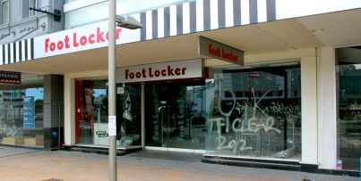 A Foot Locker sits frozen in time; spray paint on the window indicates that it was cleared for survivors on February 26, 2011.