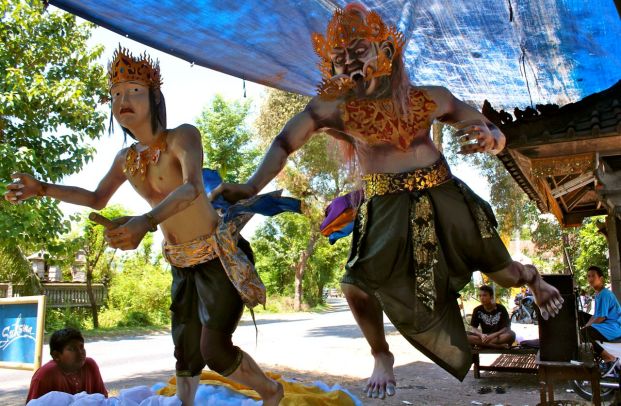 A demon chases a young prince in this "ogoh-ogoh," made out of bamboo and papier-mache by children (pictured) of Pemuteran, Bali. 
