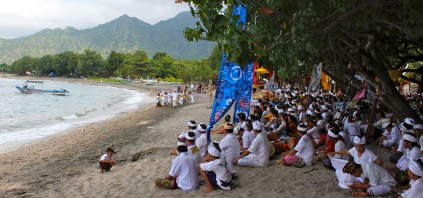 A Melasti ceremony takes place on the beach near tourist resorts in Pemuteran, Bali.  